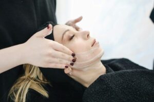Una persona aplicando a una mujer crema en la cara 