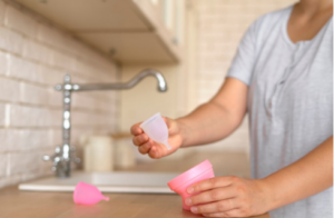 Persona realizando la limpieza de discos menstruales en una cocina.