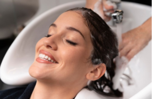 Mujer disfrutando de un lavado de cabello relajante en un salón de belleza