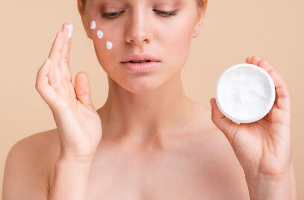 Mujer aplicando crema de leche de burra en el rostro para hidratar y regenerar