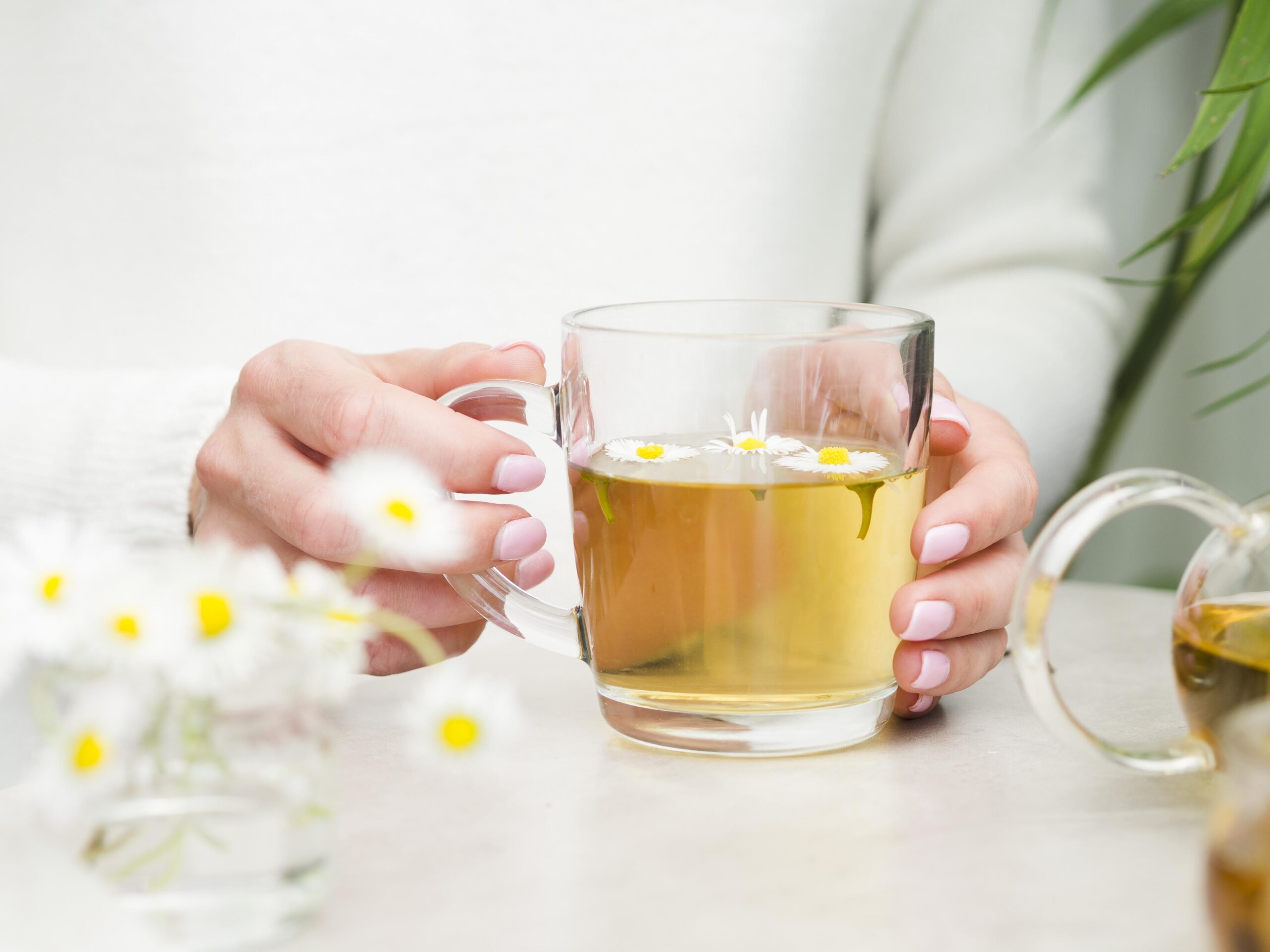 Taza de té de manzanilla caliente, ideal como té para cólicos menstruales y aliviar el malestar natural