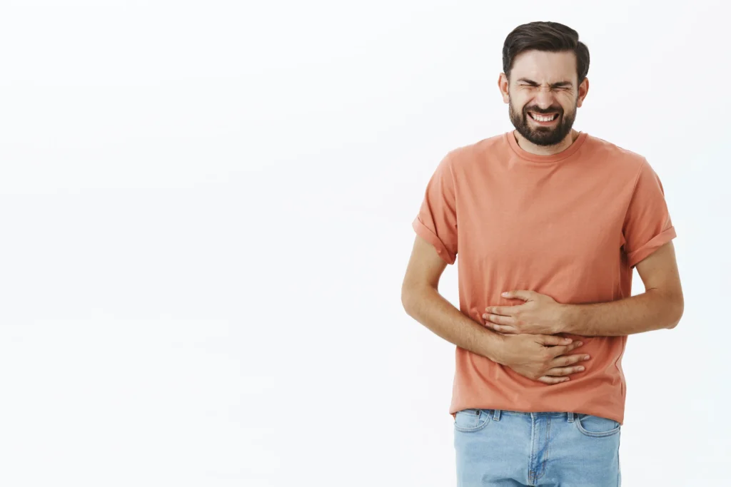 Hombre joven con dolor estomacal, una molestia común en quienes necesitan mejorar su digestión con una dieta adecuada para la colitis