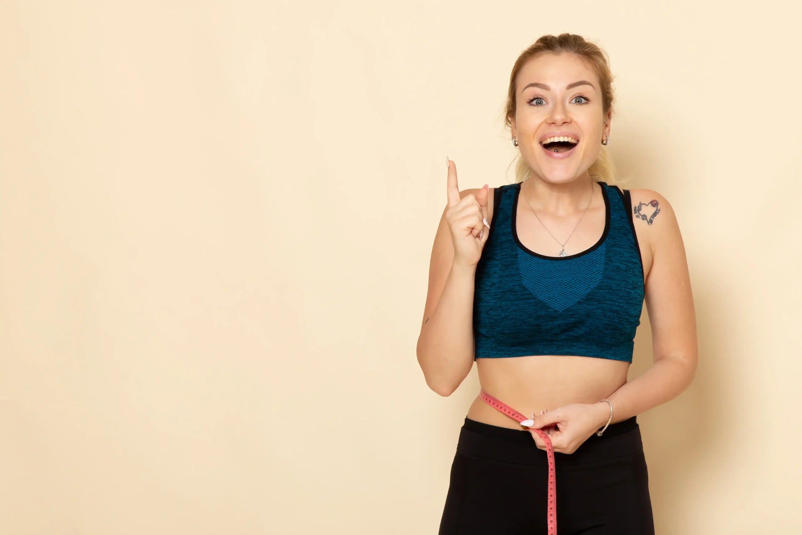 Mujer sonriente midiendo su cintura con cinta métrica, símbolo de progreso en su plan para subir de peso con ayuda de vitaminas