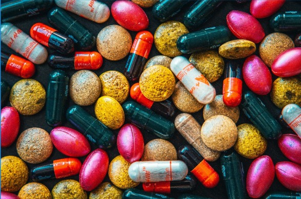 [Gran variedad de cápsulas y tabletas de diferentes colores y formas, muestra visual de suplementos nutricionales