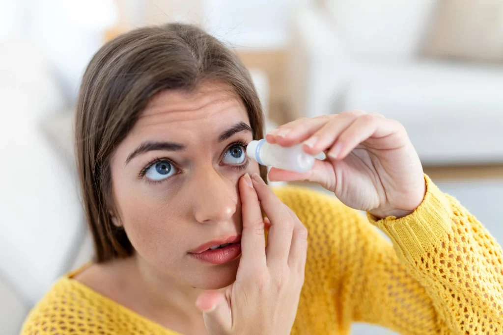 Mujer usando gotas para los ojos Mujer aplicando lubricante ocular para tratar el ojo seco o alergia