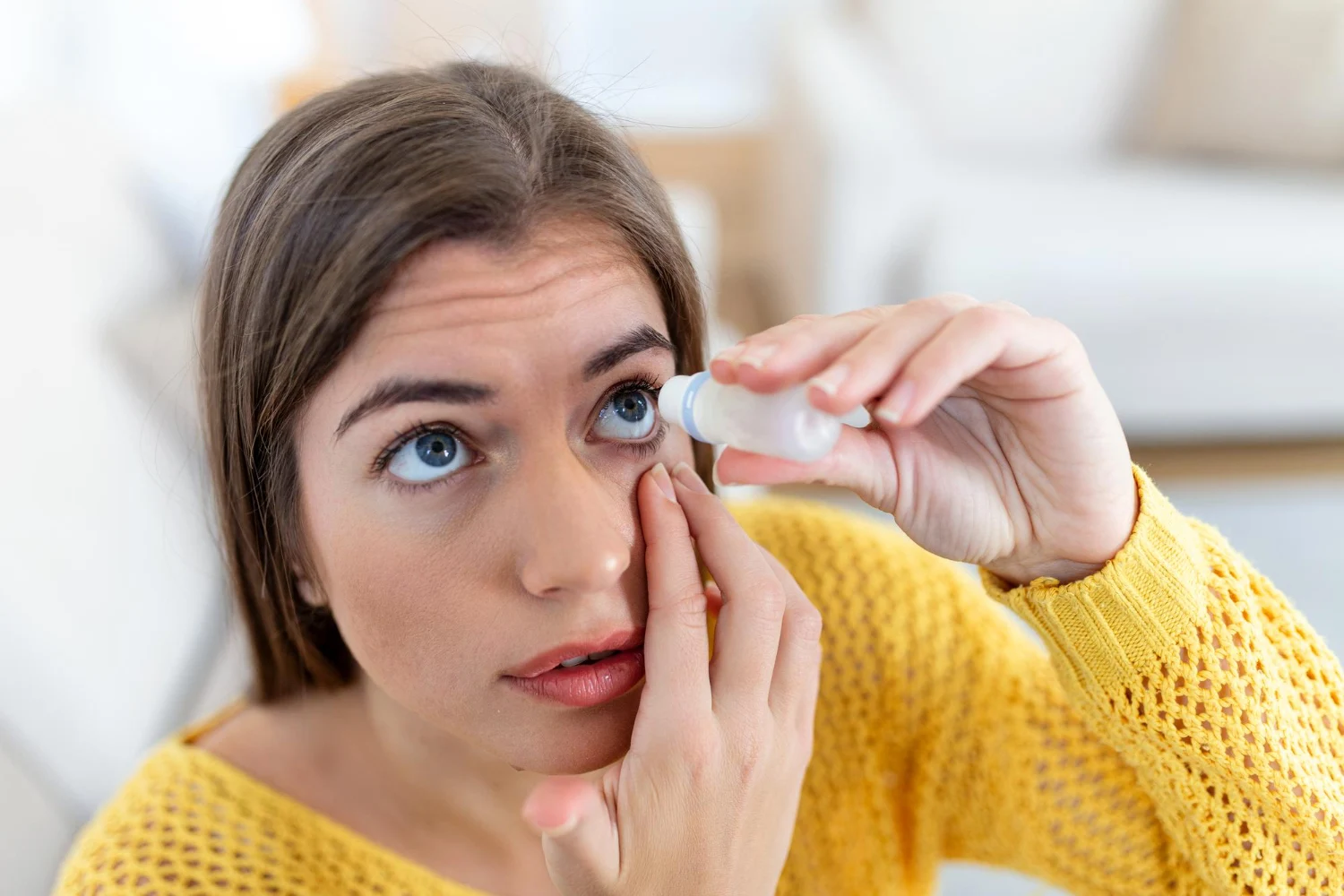 Mujer usando gotas para los ojos Mujer aplicando lubricante ocular para tratar el ojo seco o alergia