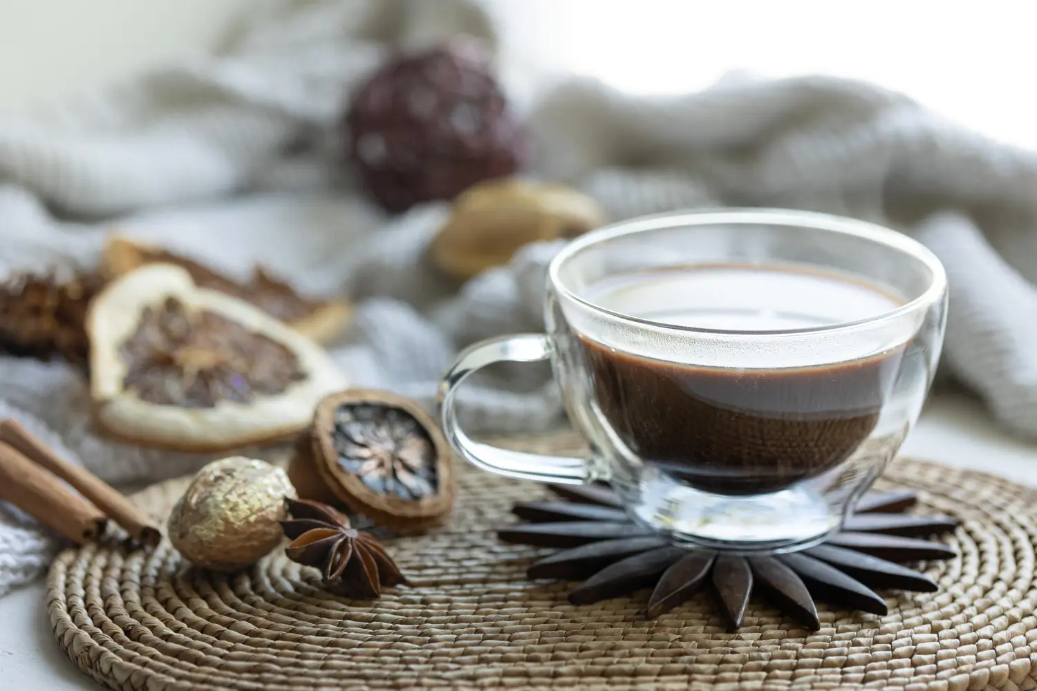 Composición con una taza de café sobre un fondo borroso con un elemento tejido